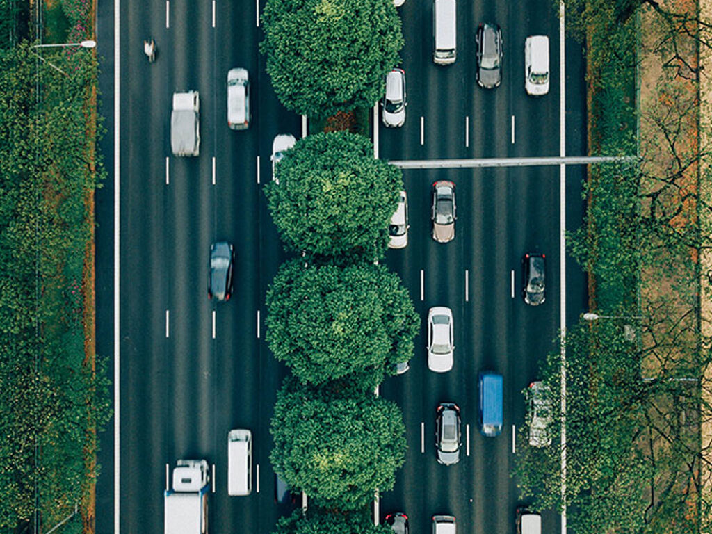 An aerial view of a highway with several lanes of traffic, where trees in the median appear to create a continuous line, demonstrating the Gestalt principle of continuation.